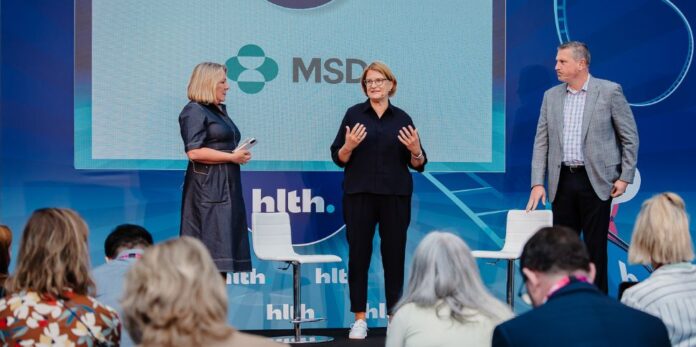 Bild von drei Menschen auf der Bühne. Aufgenommen auf der HLTH 2024, zu sehen sind Kirsten Hoyer (l.) und Joel Krikston, Managing Director Venture Investments beim MSD Global Health Innovation Fund.